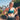 A person wearing a green sports bra and black heart rate monitor chest strap, standing near a palm tree in a sunny location.