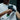A person is using a black Hyperice Hypervolt 2 Pro massage gun on their shoulder, which is visible in the image.