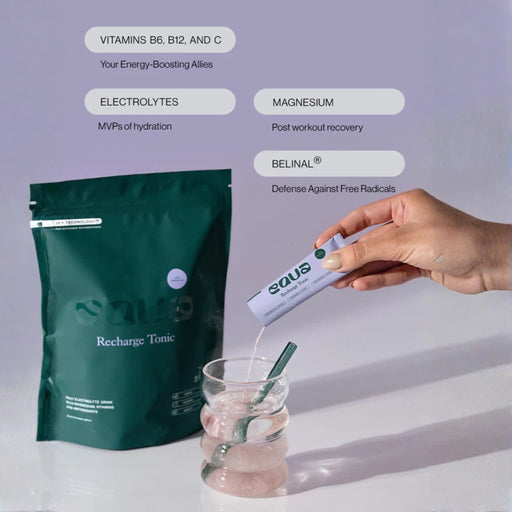 Person pouring a supplement into a glass with a green package labeled 'Recharge Tonic' on a light gray background.