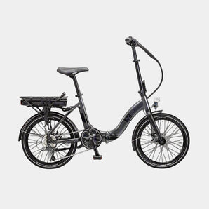Black folding bicycle on a paved surface with a modern building in the background