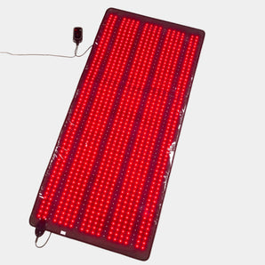 Red LED mat with power adapter on a light beige background
