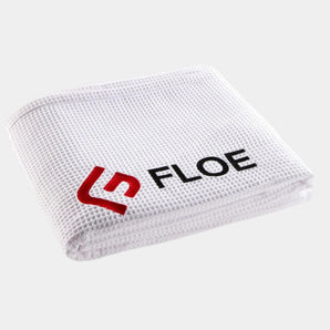 White textured towel with FLOE logo on a beige background