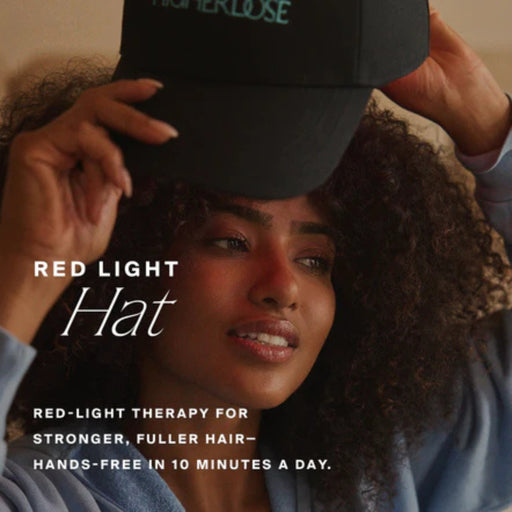 Person wearing a black cap with text about red light therapy for hair growth.
