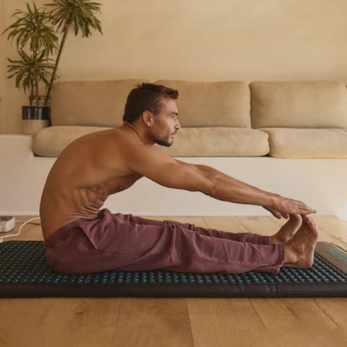 Man practicing yoga on a mat in a living room setting