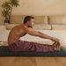 Man practicing yoga on a mat in a living room setting