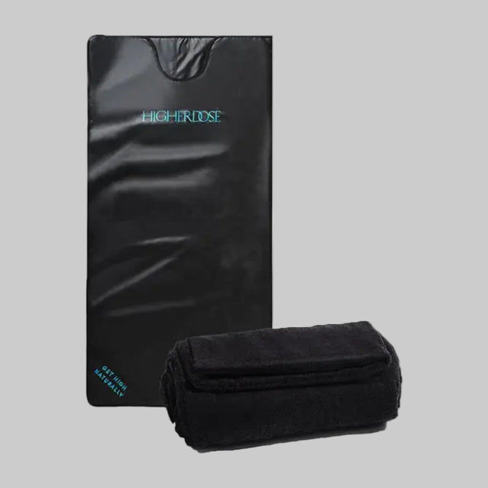 Black mat and folded black towel with 'Higher Edge' branding on a white background