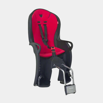 A red Hamax Kiss Child Bike Seat with black accents, featuring a secure mounting system and a quick-release button. The seat appears to be designed for comfort and safety with a shock-absorption system.