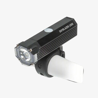 Black flashlight with white light on a gray background