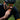 Cyclist wearing a helmet and sunglasses eating an orange snack.