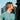 Man wearing a teal shirt with a cityscape in the background